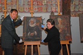 Museumsdirektor René Schiffmann und die Restauratorin Janina Hauser stellen eines der soeben ausgepackten Porträts auf die Staffelei.